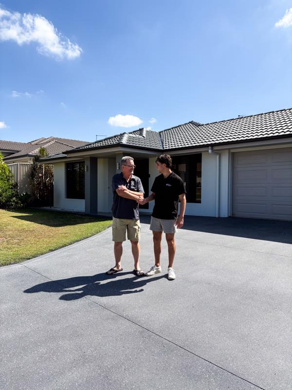 Lachlan shaking hands with a customer on a freshly sealed driveway